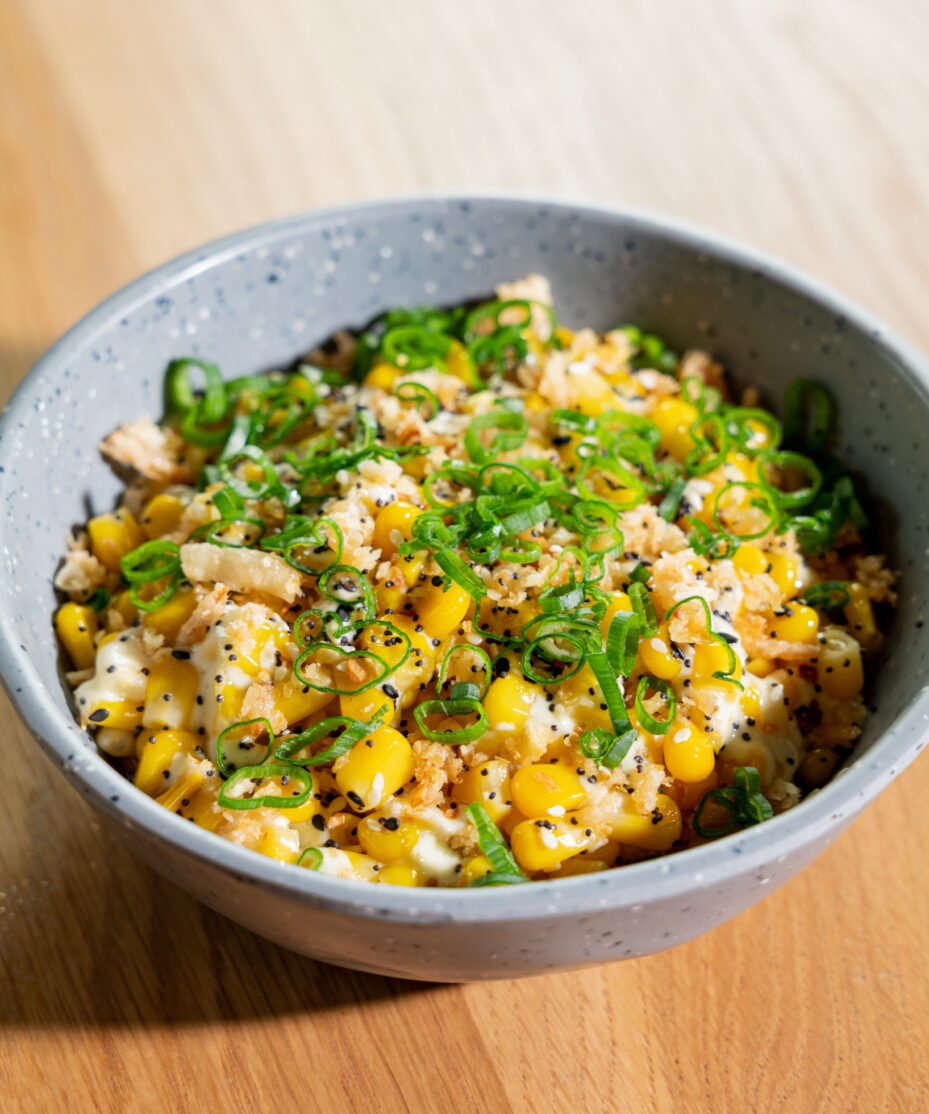 A close-up of Texas sweet corn served in a gray bowl.