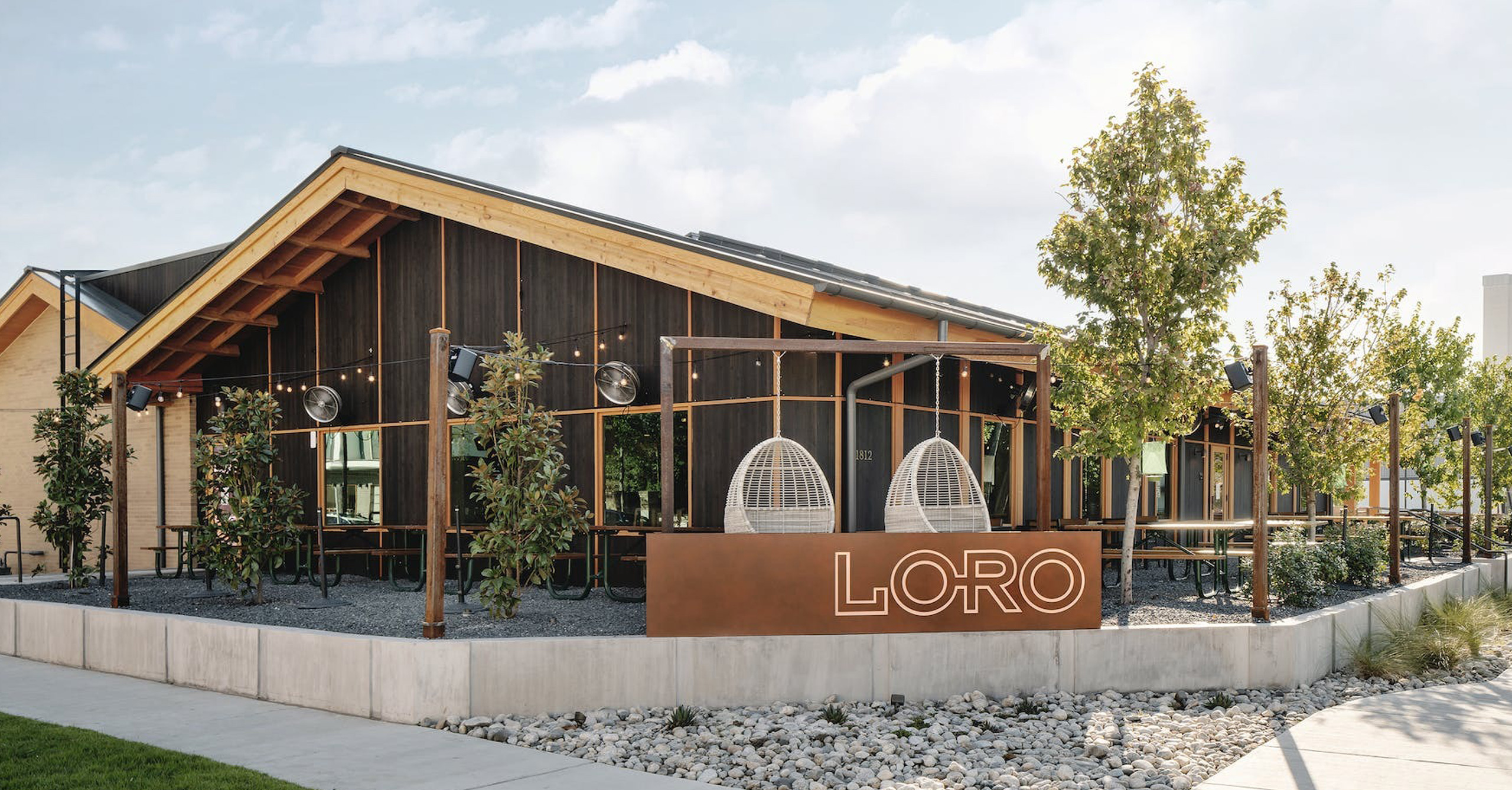 The exterior, sign, and outdoor patios of Loro Dallas East.