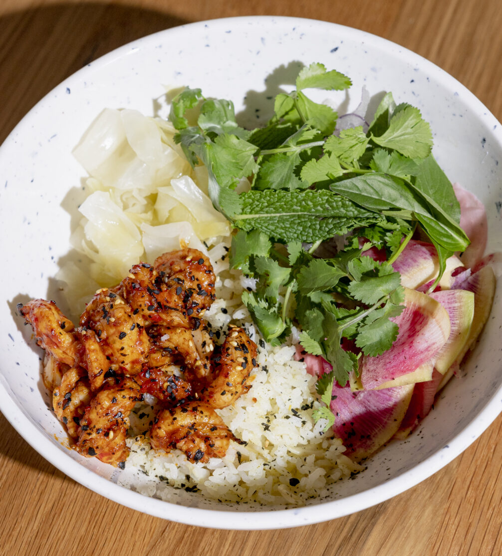 A close-up of a curry marinated shrimp rice bowl.