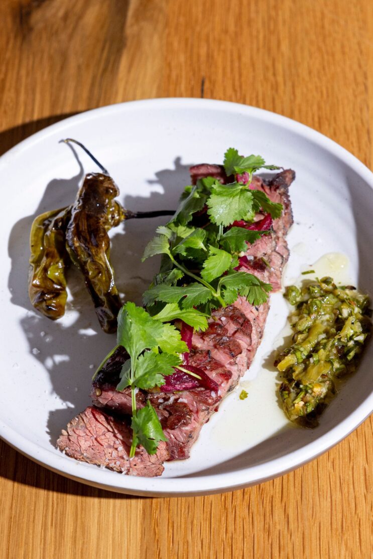 Smoked prime bavette served on a white plate.