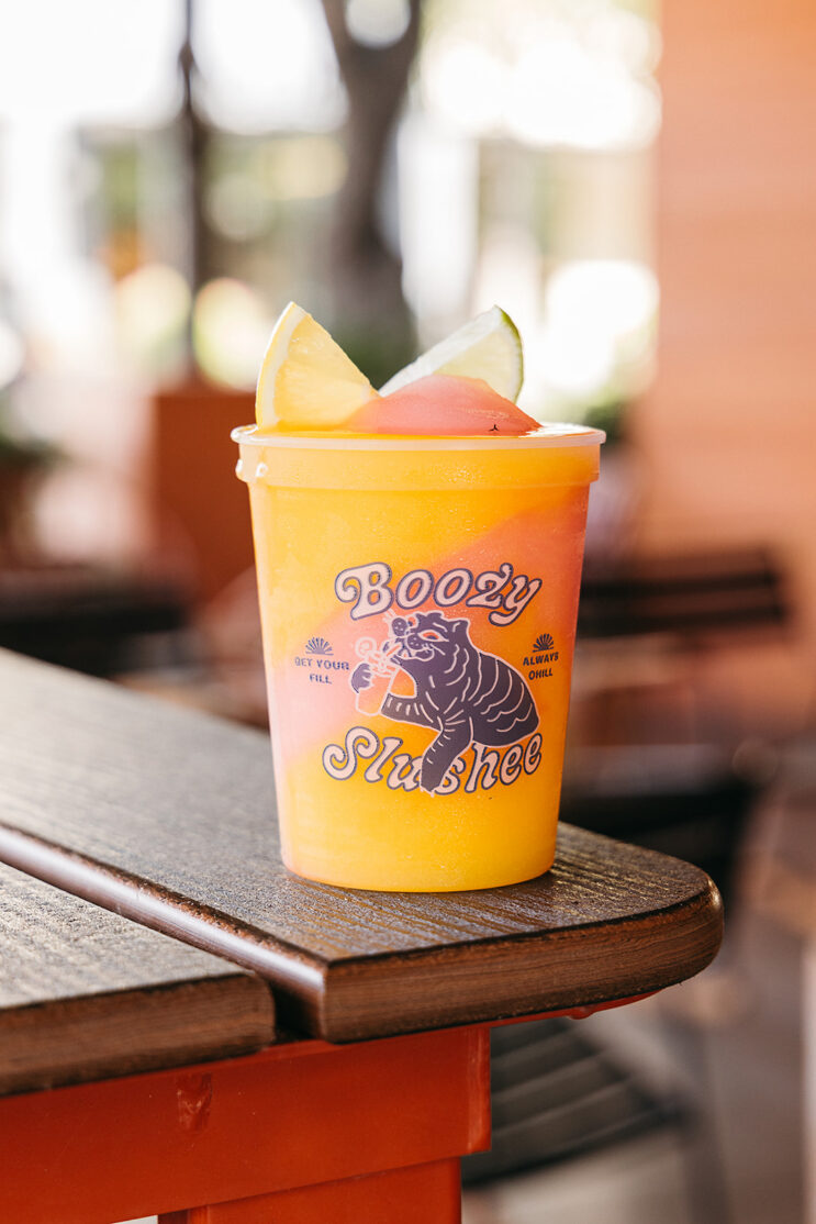 orange and pink swirl slushee in stadium cup with Loro tiger